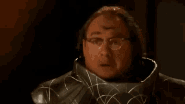 a man in a leather jacket is holding a knife in his hand .