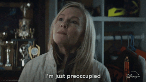 a woman says " i 'm just preoccupied " in front of a display of trophies