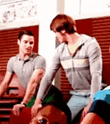 two men are standing next to each other in a room .