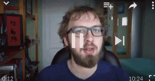 a man with glasses and a beard is sitting in front of a screen that says ' ii ' on it
