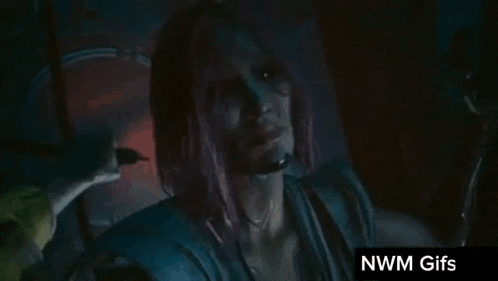 a woman with long hair is standing in a dark room with red lights .