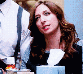 a woman sitting next to a box of tissues