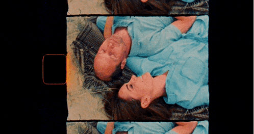 a man and a woman are laying next to each other on a bed