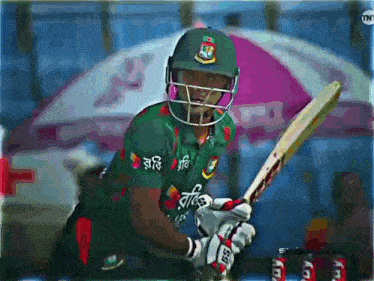 a cricket player wearing a helmet and holding a bat with a tnt logo in the background