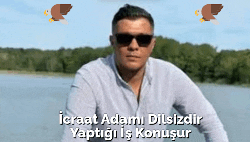 a man wearing sunglasses stands in front of a body of water with the words icraat adami dilsizdir written below him