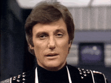 a close up of a man 's face wearing a black jacket