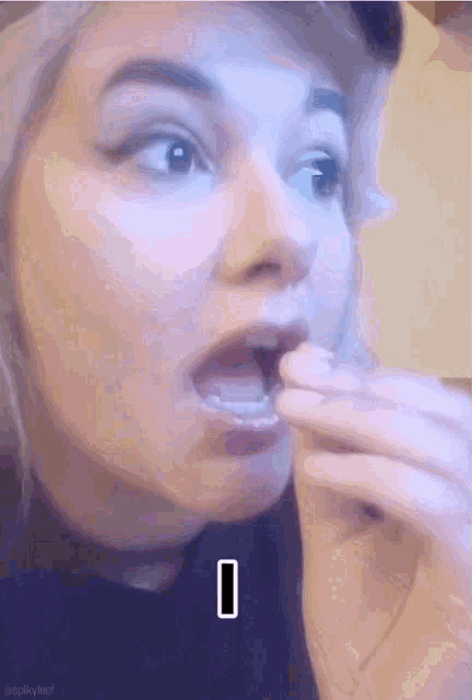 a close up of a woman 's face with the letter i in the lower right corner