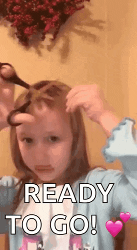 a little girl is holding a pair of scissors in her hand and says ready to go