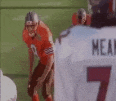 a football player in a red uniform is standing on a field .