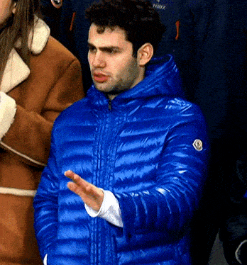 a man wearing a blue jacket with the word moncler on the front