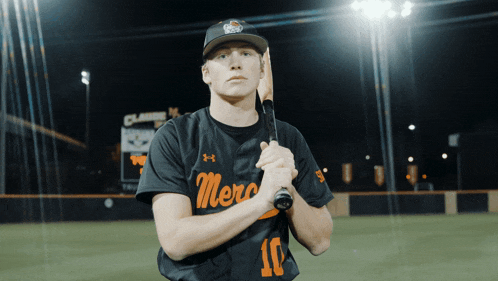 a baseball player holding a bat with the number 10 on his jersey