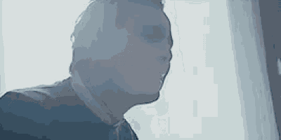 a man is standing in front of a window looking out .
