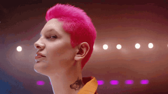 a woman with pink hair is wearing a yellow jacket