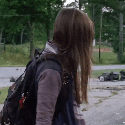 a woman wearing a backpack with a sticker on it that says ' i love you '