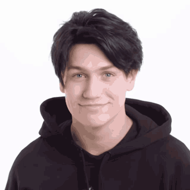 a young man wearing a black hoodie looks at the camera