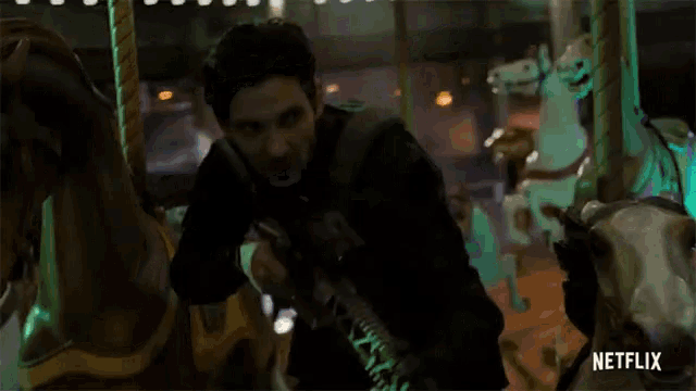 a man is holding a gun in front of a merry go round with netflix written on the bottom right