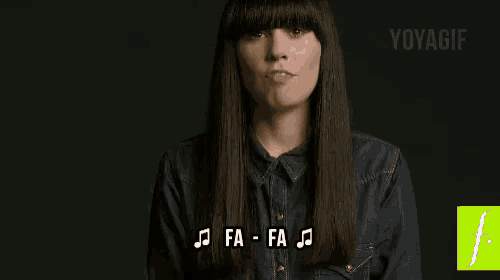 a woman in a denim shirt is singing a song with music notes on her face .