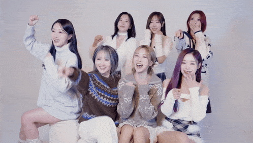a group of girls are posing for a picture and one of them is pointing