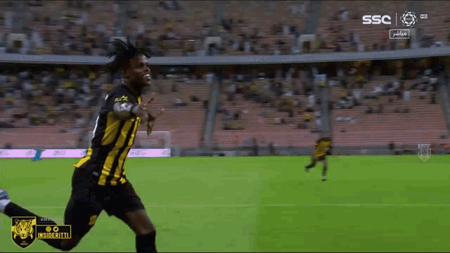 a soccer player is running on a field with ssc written on the screen