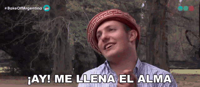 a man wearing a greek key hat says " ay me llena el alma "