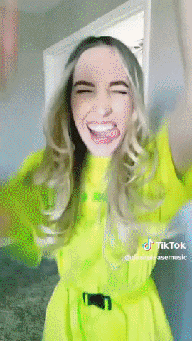 a woman in a neon yellow outfit is making a funny face