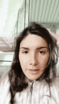 a close up of a woman 's face with a window in the background