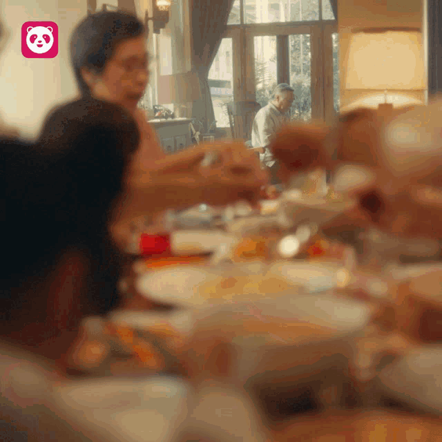 a group of people are sitting at a table with a panda icon in the background