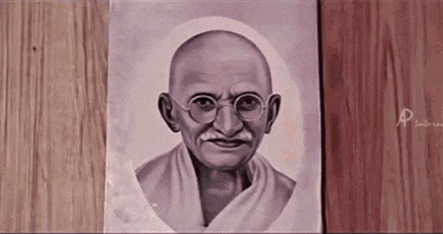 a portrait of mahatma gandhi is on a wooden surface