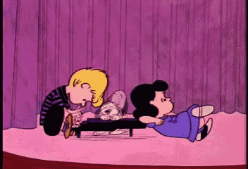 a cartoon of snoopy and lucy playing with a puppy