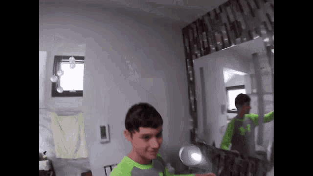 a man in a green shirt is standing in front of a mirror