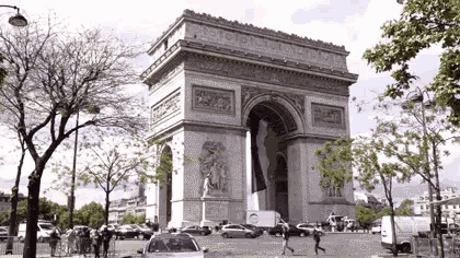 the triumphal arch in paris is surrounded by cars and trees
