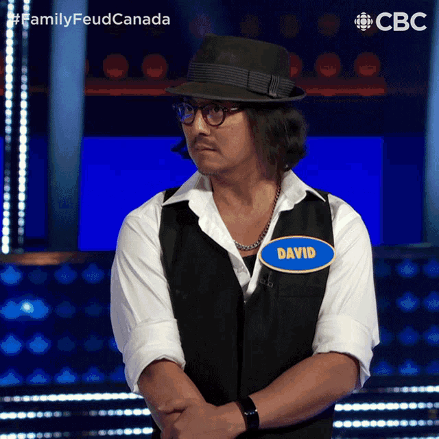a man wearing a hat and glasses has a name tag that says david