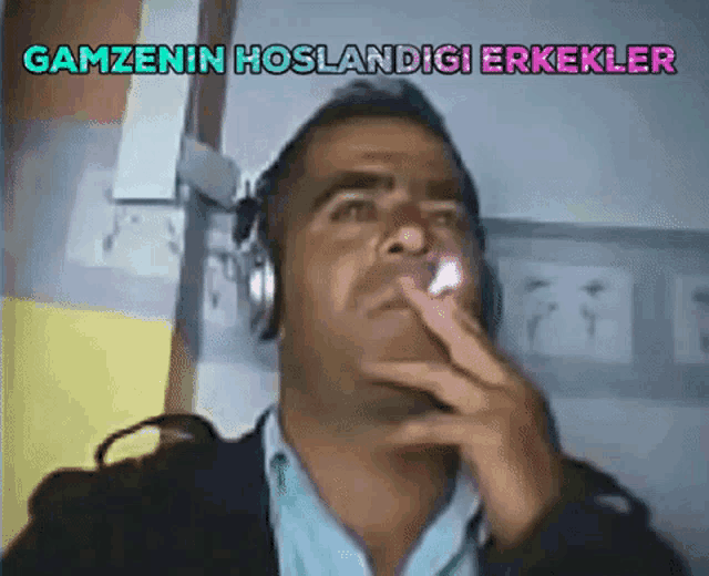 a man wearing headphones is smoking a cigarette with the words gamzenin hoslandigi erkekler written above him