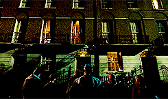 a group of people are standing in front of a large building