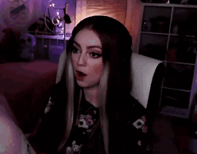 a woman is sitting on a couch with her mouth open and her hands out .