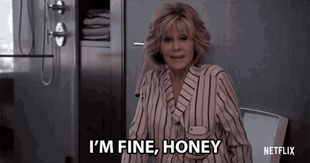 a woman in a bathrobe says i 'm fine honey while sitting on a toilet