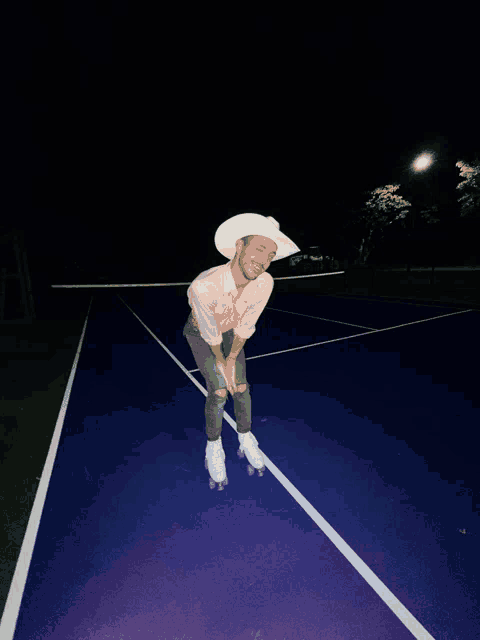 a man in a cowboy hat is rollerblading on a tennis court at night