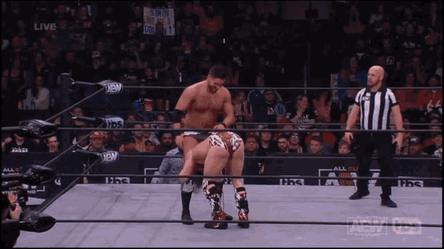 two men in a wrestling ring with a sign that says " suicide squad " on it