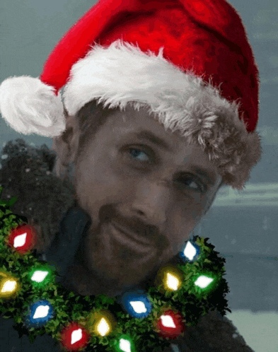 a man wearing a santa hat has a wreath around his neck