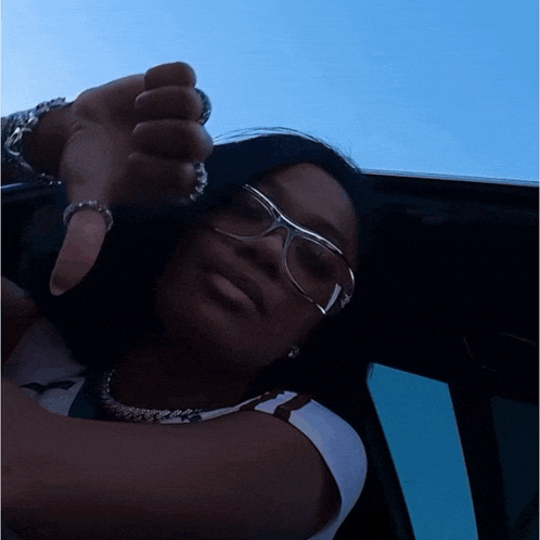 a woman wearing glasses giving a thumbs down