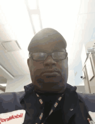 a man wearing glasses and a lanyard with the word mobil on it