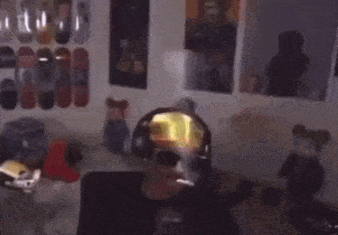 a man wearing headphones is smoking a cigarette in a bedroom .