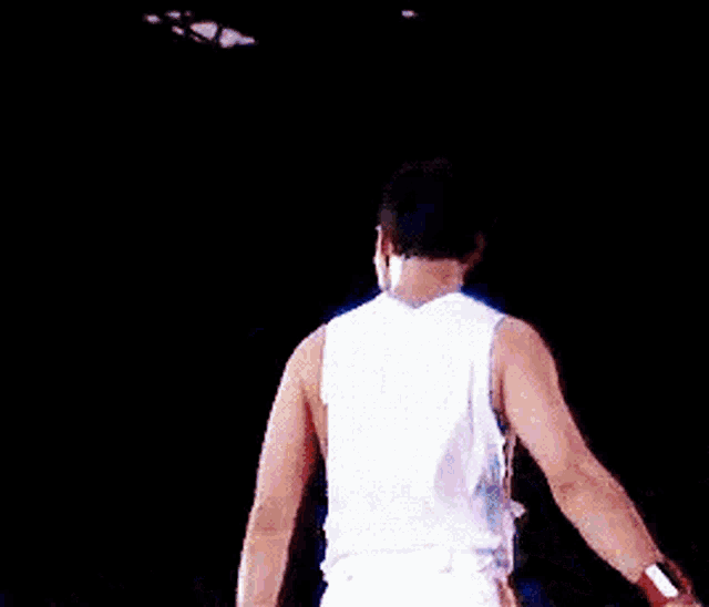 a man is dancing on a stage in front of a crowd of people .