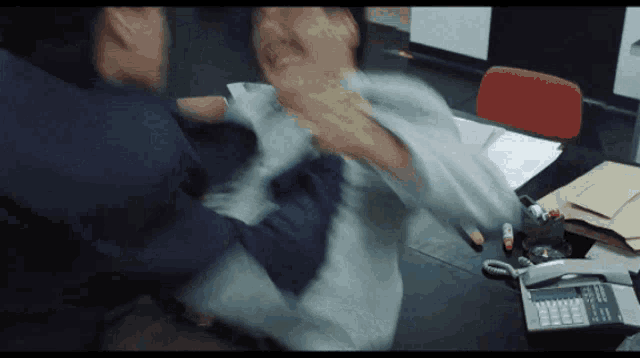 a man is being punched in the face by another man in front of a calculator