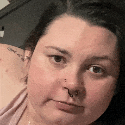a woman with a tattoo on her shoulder has a nose ring