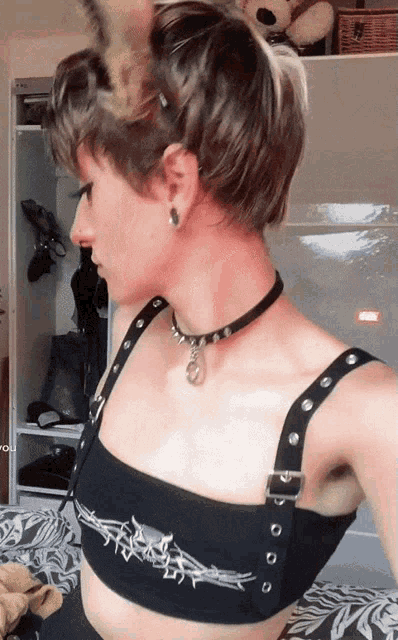 a woman wearing a choker and a crop top with spikes on it