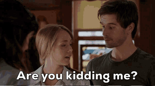 a man and a woman are standing next to each other and the woman asks the man if he is kidding her