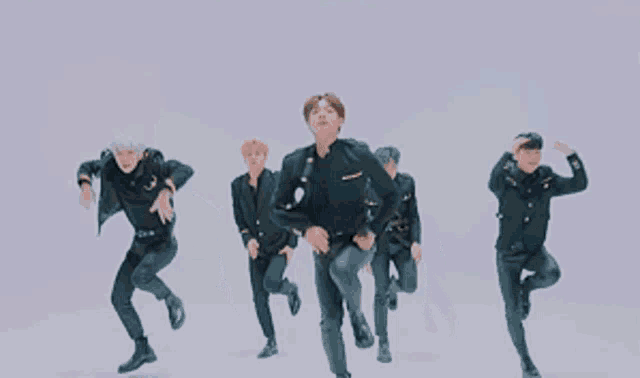 a group of young men in military uniforms are performing a dance