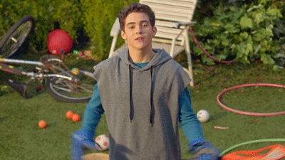 a young man in a hoodie is holding a hula hoop in his hands