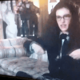 a woman wearing glasses is sitting on a couch